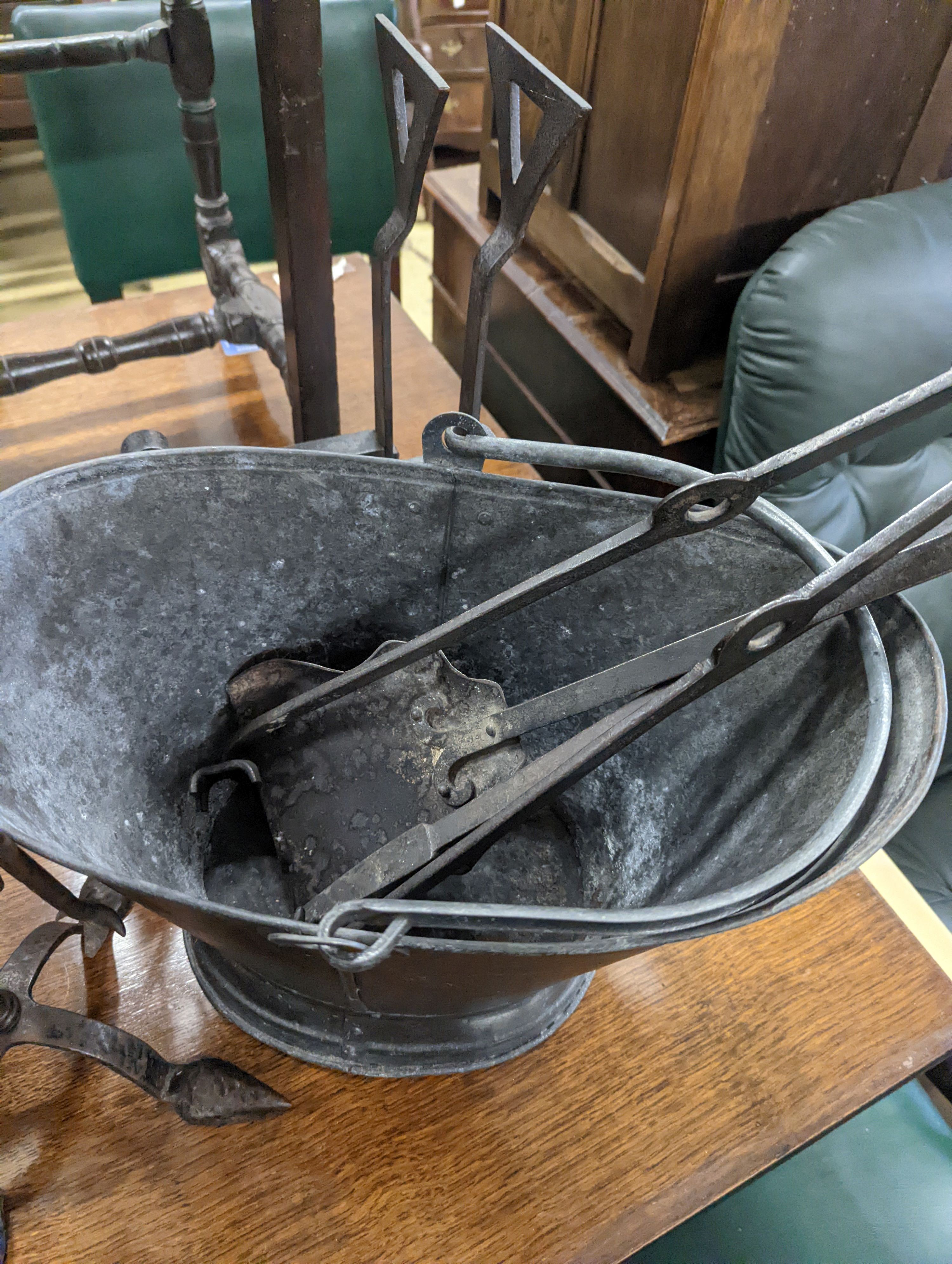 Two sets of wrought iron fire implements, a coal bucket and a pair of dogs